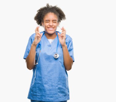 Genç afro Amerikalı doktor kadın geçiş parmakları umut ve gözler gülümseyen izole arka plan yüzünden kapalı. Şans ve batıl kavramı.