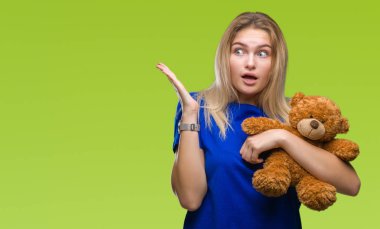 Sevimli Ayıcık büyük gülümseme ile çığlık zaferini kutluyor ve ellerini kaldırdı izole arka plan çok mutlu ve heyecanlı, kazanan ifade üzerinde tutan genç beyaz kadın