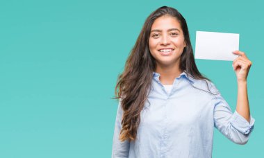 Ayakta ve diş gösterilen kendine güvenen bir gülümsemeyle gülümseyerek mutlu bir yüz ile izole arka plan üzerinde boş kartı tutan genç Arap kadın