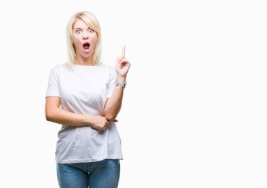Başarılı fikirle izole arka plan işaret parmağı üzerinde beyaz t-shirt giyen genç güzel sarışın bir kadın. Çıktıktan ve mutlu. Bir numara.