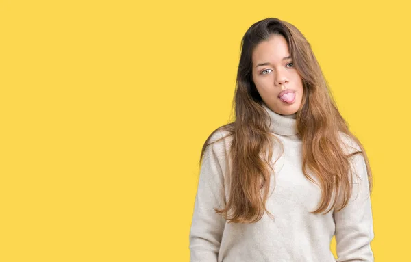 舌を付着分離の背景にタートルネックのセーターを着ている若い美しいブルネットの女性を面白い表現に満足 感情の概念 — ストック写真