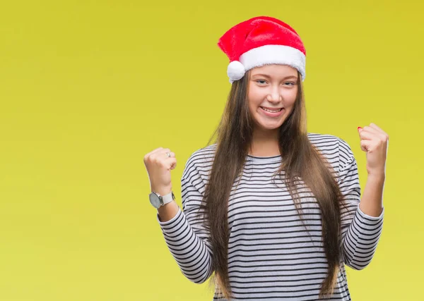 上孤立した背景を祝うクリスマスの帽子をかぶって若い美しい白人女性驚いて腕を上げると成功のため驚くし 目を開きます 勝者の概念 — ストック写真