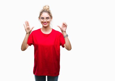 Gösterilen ve parmakları ile işaret izole arka plan üzerinde kırmızı t-shirt ve gözlük giyen genç güzel sarışın kadın kendinden emin ve mutlu gülümseyerek süre 6 numara.