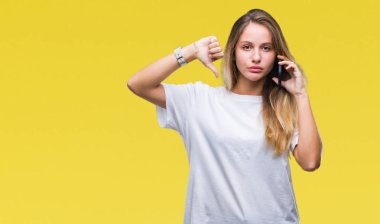 Genç güzel sarışın kadın üzerinde Smartphone kullanarak arama arka plan kızgın yüzü, eksi işareti aşağı antipati başparmak ile gösterilen, ret kavramı ile izole