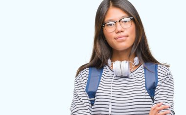 Üzerinde kulaklık ve sırt çantası giyen genç Asyalı öğrenci kadın mutlu yüz ile gülümseyerek kameraya seyir silah geçti arka plan izole. Olumlu bir kişi.