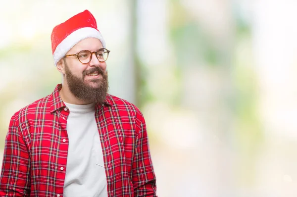 以上クリスマス帽子をかぶっている若い白人男分離背景が笑顔で側に自然な表現の顔に離れています 自信を持って笑ってください — ストック写真