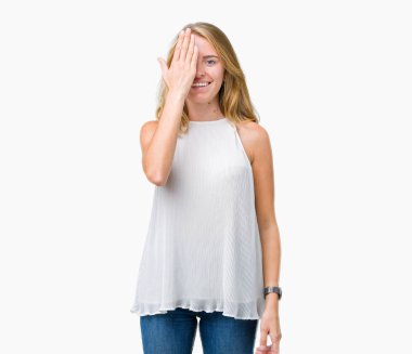 El yüz ve sürpriz duygu kendinden emin gülümseme ile tek gözüyle kapsayan izole arka plan güzel genç zarif kadın.