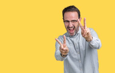 Zafer işareti yapıyor parmak gösterilen kamera seyir gülümseyen izole arka plan üzerinde gözlük takan yakışıklı orta yaş zarif komuta sizde. İki numaralı.