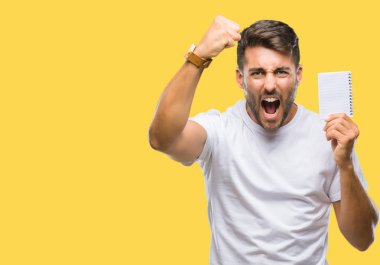 Genç yakışıklı adam holding defter üzerinde izole arka rahatsız ve boşa çıkarmak ile öfke, çılgın ve yükseltilmiş eliyle diye bağıran öfke kavramı bağırarak.