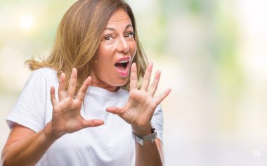 Şokta bağırarak orta yaş üst düzey İspanyol kadın izole arka plan korkuyor ve korku ifade dur hareketi el ile ile çok korkmuş. Panik kavramı.