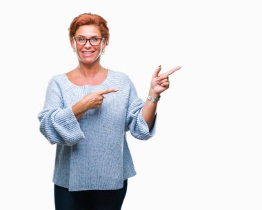 Atrractive üst düzey beyaz Kızıl saçlı kadın gülümseyerek ve iki elleri ve parmakları ile tarafına işaret kamera bakarak izole arka plan üzerinde gözlük.