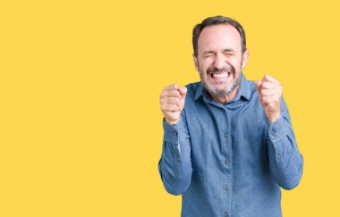 Zafer kutluyor gülümseyen yakışıklı orta yaş izole arka plan üzerinde zarif komuta sizde heyecanlı silah ile başarı için kaldırdı. Kazanan kavramı.