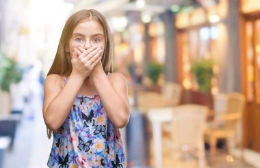 İzole arka plan ağız hata için elleriyle kapsayan şok üzerinde renkli elbise genç güzel kız. Gizli kavramı.