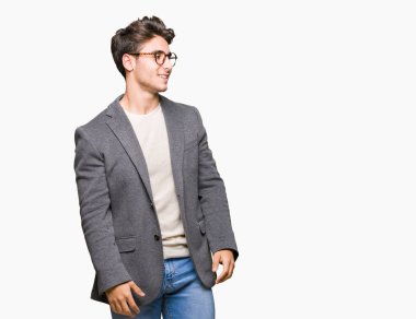 İzole arka plan uzak tarafına gülümseme ile yüzünde, doğal ifade bakmaktan gözlüklü genç iş adamı. Kendine güvenen gülüyor.