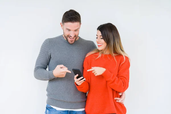 Young Couple Using Smartphone Isolated Background Very Happy Pointing Hand — Stock Photo, Image