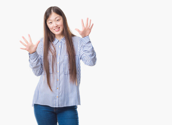 Молодая китаянка на изолированном фоне показывает и указывает пальцами номер десять, улыбаясь уверенно и счастливо
.
