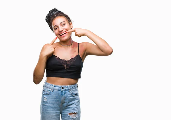 stock image Young braided hair african american with pigmentation blemish birth mark over isolated background smiling confident showing and pointing with fingers teeth and mouth. Health concept.