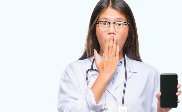 Young Asian Doctor Woman Holding Smartphone Isolated Background Cover Mouth — Stock Photo, Image