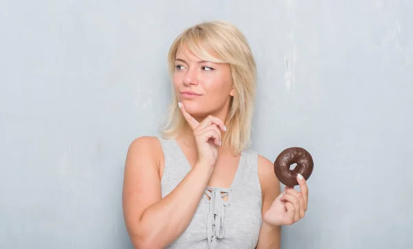 Kaukasiska Vuxen Kvinna Över Grå Grunge Vägg Äta Choklad Donut — Stockfoto