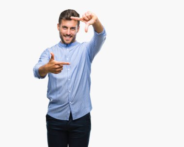 Yakışıklı delikanlı elle yapma çerçeve ve parmakları ile mutlu yüz gülümseyen izole arka plan üzerinde. Yaratıcılık ve Fotoğrafçılık kavramı.