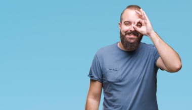 Genç beyaz hipster adam gülümsüyor, parmakları ile mutlu yüz üzerinden seyir göz el ile ok jest yapıyor izole arka plan.
