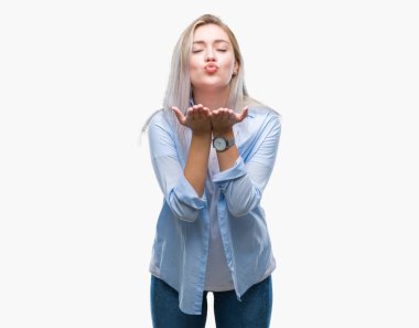 Sarışın genç kadın bir öpücük el ile güzel ve seksi olmak hava üfleme kamera bakarak izole arka plan üzerinde. Aşk ifade.