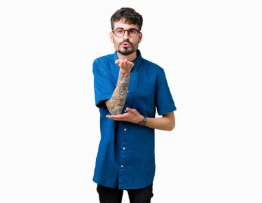 Bir öpücük el ile güzel ve seksi olmak hava üfleme kamera bakarak izole arka plan üzerinde gözlük takan yakışıklı delikanlı. Aşk ifade.