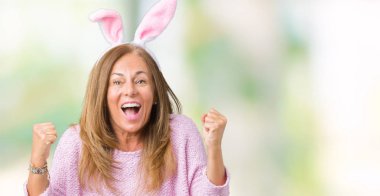 Paskalya tavşan kulakları izole arka plan kutlama üzerinde giyen orta yaş esmer kadın şaşırttı ve silah ile başarı için yükseltilmiş ve açık gözler hayrete düşürdü. Kazanan kavramı.