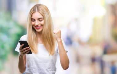 Duygu tezahürat smartphone gurur çığlık ve zafer ve başarı çok heyecanlı, kutluyor izole arka plan üzerinde kullanan genç güzel sarışın kadın