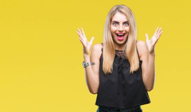 Genç güzel sarışın ve mavi gözlü kadın deli kutluyor arka plan izole ve başarı için kaldırdı kollarını açarak hayrete ve heyecanlı çığlık gözleri açık. Kazanan kavramı