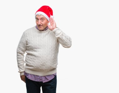 Yakışıklı komuta sizde bir işitme söylenti ya da dedikodu için dinleme kulak üzerinde el ile gülümseyen izole arka plan üzerinde Noel şapka giyiyor. Sağırlık kavramı.
