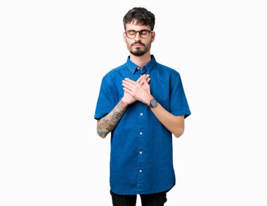 Yakışıklı delikanlı ile gülümseyen izole arka plan üzerinde gözlük takan kapalı gözler ve yüzünde minnettar jest ile göğüs üzerinde eller. Sağlık kavramı.