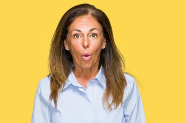 Güzel orta yaş iş yetişkin kadın izole arka plan korkuyor ve sürpriz ifade ile şok yüzünden korku ve yüz heyecanlı.