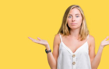 Güzel genç kadın yüzünden izole arka plan clueless ve şaşkın bir ifadeyle kollar ve eller kaldırdı. Şüphe kavramı.