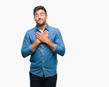 Yakışıklı delikanlı ile gülümseyen izole arka plan üzerinde kapalı gözler ve yüzünde minnettar jest ile göğüs üzerinde eller. Sağlık kavramı.