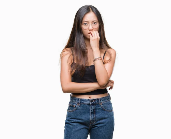 若いアジア女性の眼鏡を強調し 両手の爪を噛んで口の中で神経を探して孤立の背景の上 不安の問題 — ストック写真