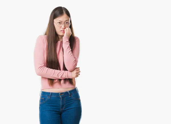 年轻的中国妇女在孤立的背景戴眼镜看起来紧张和紧张的手在嘴咬指甲 焦虑问题 — 图库照片