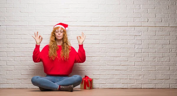 Young Redhead Woman Sitting Brick Wall Wearing Christmas Hat Relax — Stock Photo, Image