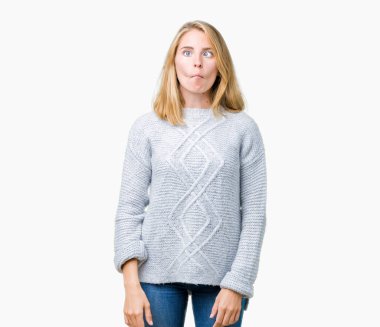 İzole arka plan yapma balık yüzüne dudaklı, çılgın ve komik bir jest kış kazak giyen güzel genç kadın. Komik ifade.