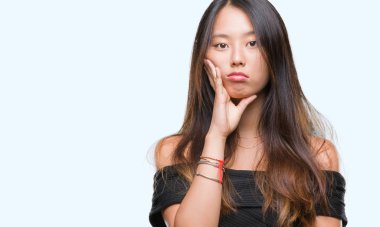 İzole arka plan düşünme seyir üzerinde Genç Asyalı kadın yorgun ve sıkılmış çapraz silah depresyon sorunları ile.