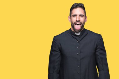 Genç Hıristiyan rahip dilini izole arka plan üzerinde out komik ifade ile mutlu. Duygu kavramı.