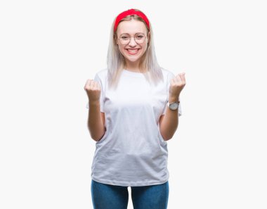 Genç Sarışın kadın izole arka plan üzerinde kutluyor gözlük takan şaşırttı ve silah ile başarı için yükseltilmiş ve açık gözler hayrete düşürdü. Kazanan kavramı.