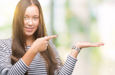 Genç güzel beyaz kadın üzerinden hayran ve el ile sunulması ve parmak ile işaret ederken kameraya gülümseyen izole arka plan.