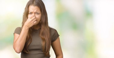 Bir şey pis ve iğrenç kokulu izole arka plan, dayanılmaz koku, holding nefes burun parmaklar ile genç güzel esmer kadın. Kötü kokuyor kavramı.