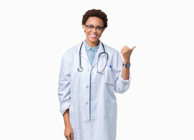 Seyir ve başparmak yanında yukarıyı mutlu yüz ile gülümseyen izole arka plan üzerinde tıbbi ceket giyen genç Afro-Amerikan doktor kadın.