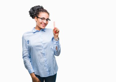 Genç ve kendinden emin ve mutlu gülümseyerek süre parmak numaralı yukarıyı gösteren izole arka plan üzerinde gözlük takan saç Afro-Amerikan iş kız örgülü.