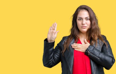 Artı boyutu genç kadın güzel üzerinde bir moda deri ceket giyiyor izole arka plan göğüs ve bir sadakat sözü yemin yapma avuç, el ile küfür