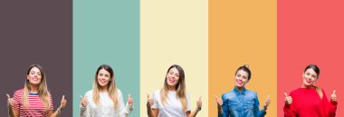 Kolaj üzerinde el ile pozitif jest yapıyor renkli vintage izole arka plan başarı işareti başparmak gülümseyen ve mutlu genç güzel kadın. Neşeli bir ifadeyle, kazanan jest kameraya bakıyor.