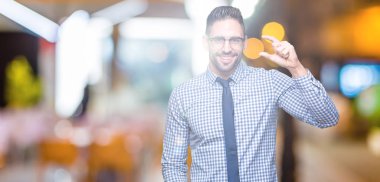 İzole arka plan gülümseyen ve boyutu işaret parmaklı ararken ve kamera işi el ile kendinden emin eller üzerinde gözlük takan genç iş adamı. Ölçü kavramı.