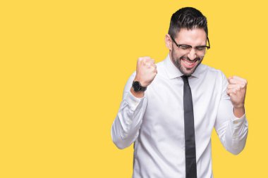 Gülümseyen ve başarı için çığlık izole arka plan çok mutlu ve heyecanlı kaldırdı, silah ile kazanan jest yapıyor üzerinde gözlük takan genç yakışıklı iş adamı. Kutlama kavramı.